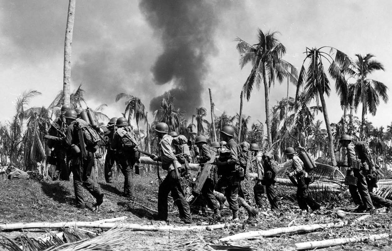 Troops of 12th Cavalry move from beach, past splintered trees and fires caused by heavy bombardment preceding their landing on Leyte Island,
Philippine Islands, October 20, 1944 (U.S. Army Signal Corps/Wienke)